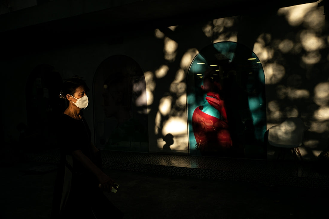a woman wearing a face mask walking down a street