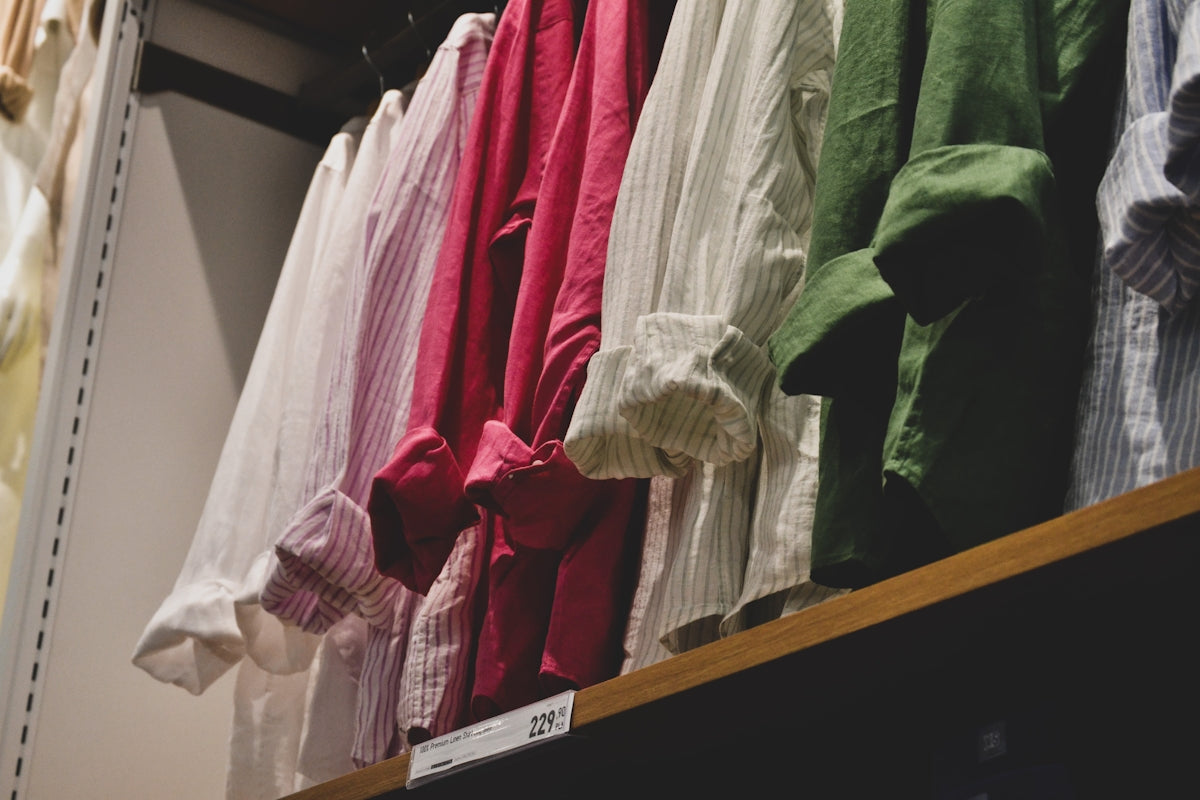 a row of shirts hanging on a rack in a store