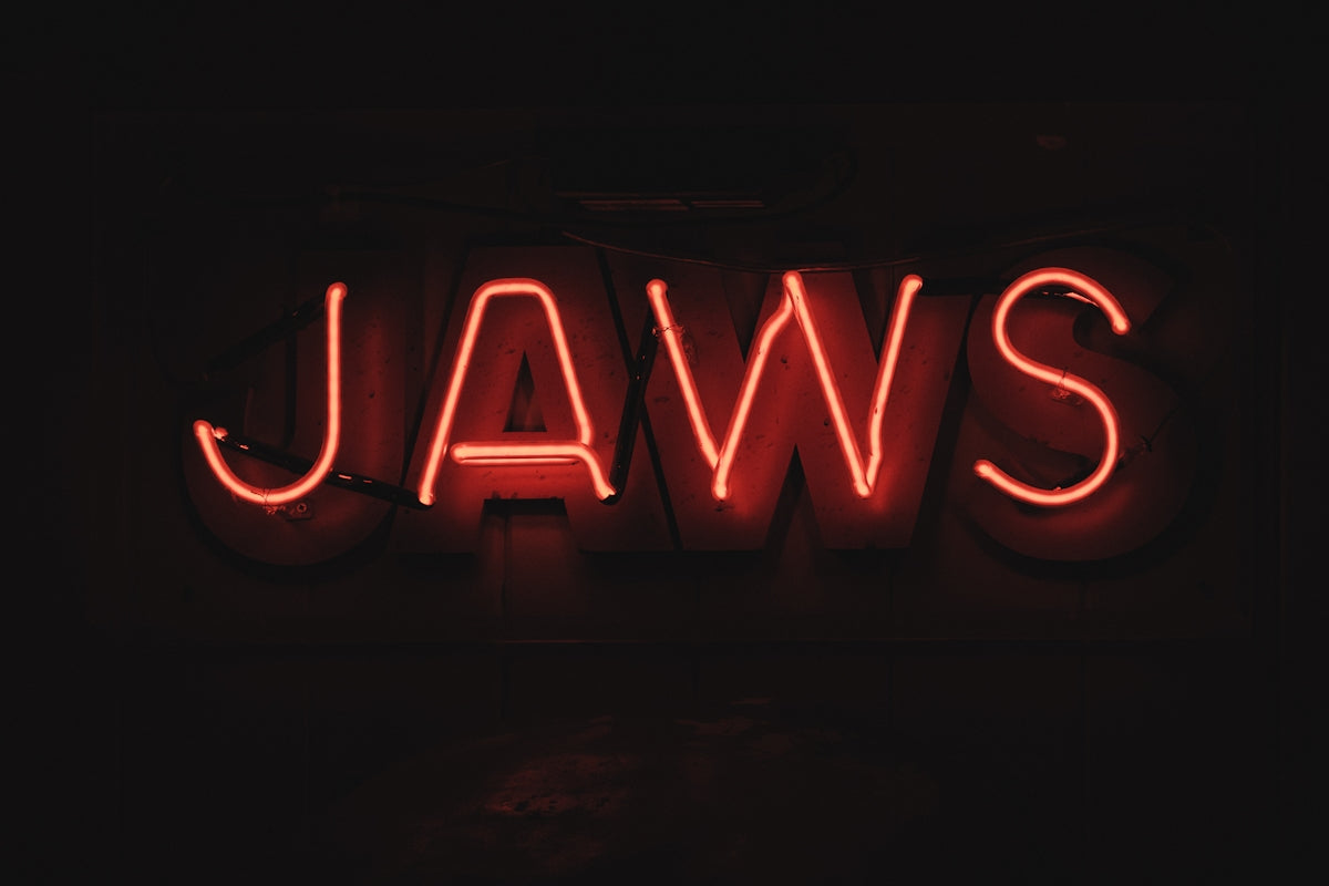 A red neon sign that says jaws