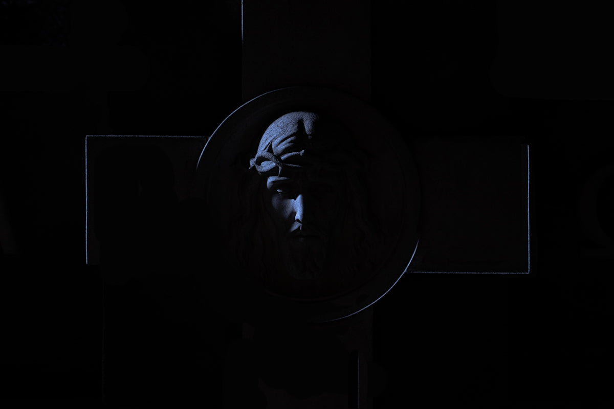 A dark, ominous symbol with a face in-shadowed face.