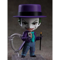 Lila-hattad Joker-figur i lila kostym med turkos scarf och rutiga byxor, håller kort och käpp