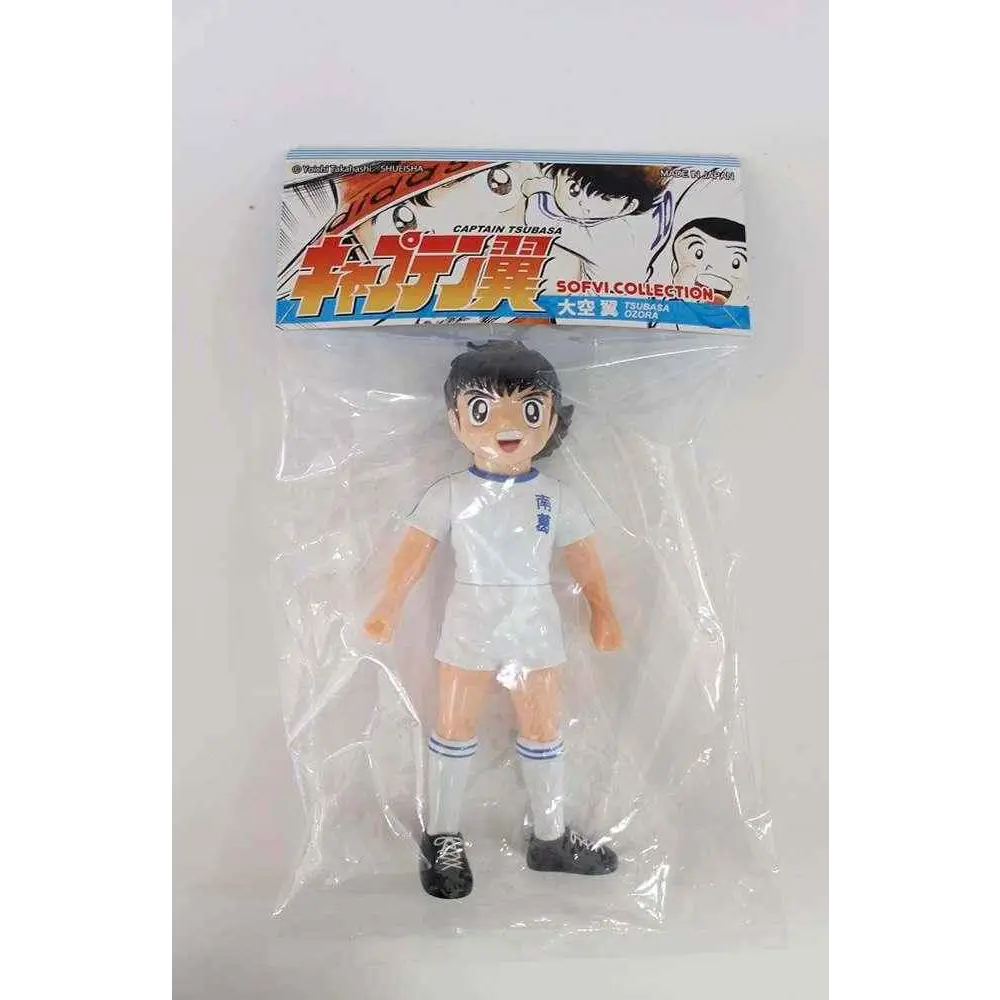 Vit Captain Tsubasa Mjuka vinylfigur: vit plastfigur i vit uniform med blå kanter och svarta skor i klar plastförpackning