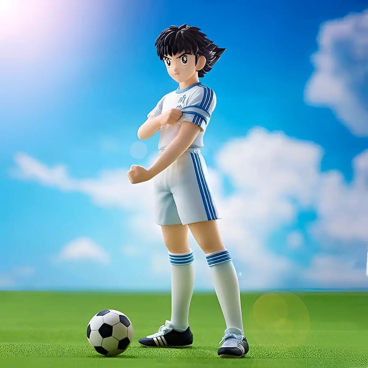 Captain Tsubasa Ozora figurin i vit-blå uniform på gräs med boll