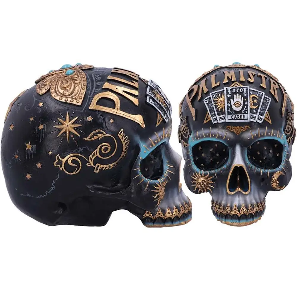 Svart och guld dekorerad skallefigur med himmelska motiv, turkosa accenter och palmist-text