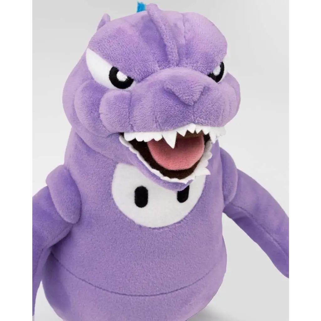 Lila Fall Guys Godzilla plush med brett tandigt leende och vita ögon. Hållbar kvalitet