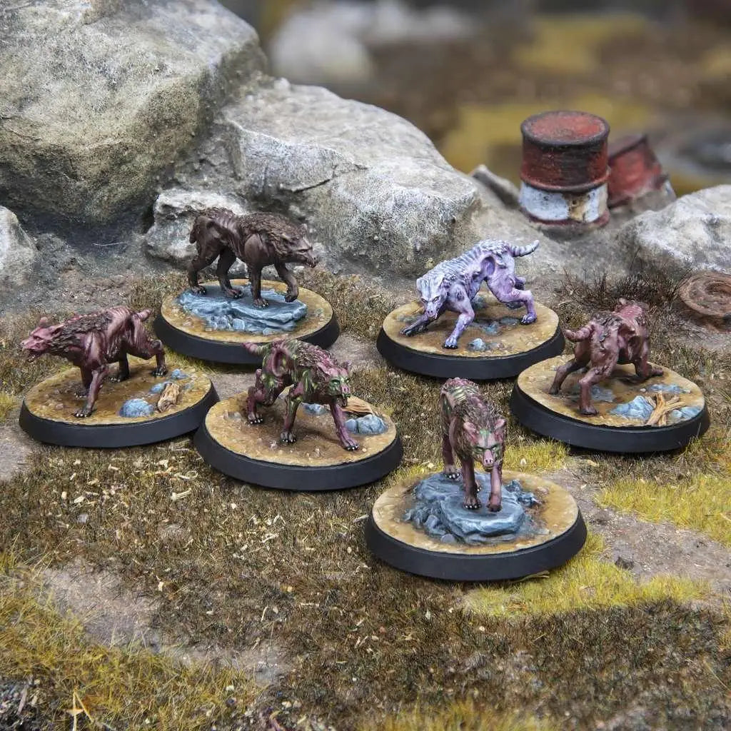 Handmålade miniatyrvargar på runda baser i Fallout WW Kreatur: Mongrel Scavenging Pack, med detaljerad päls och färger i brunt, lila och grönt