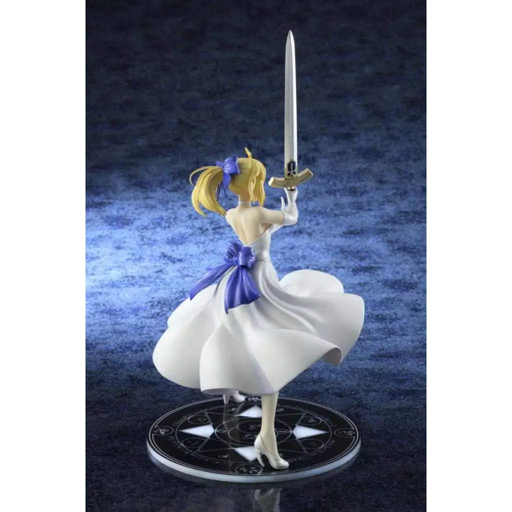 Vit figur av Saber i vit klänning med lila rosett och silver svärd