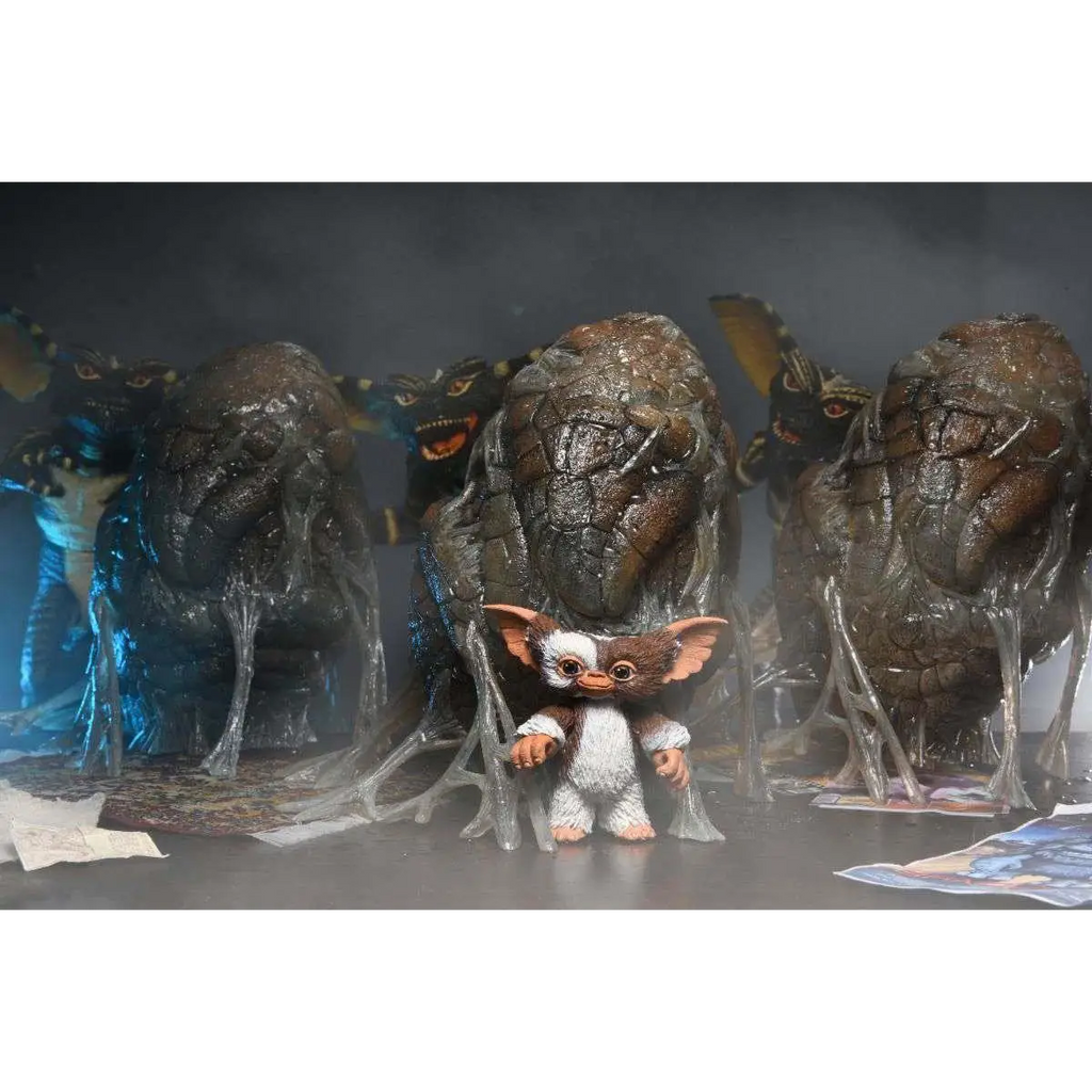 Liten söt gremlin-figur med brunt och vitt hår, stora öron, framför hotfulla varelser i Gremlins 1984 Tillbehörspaket