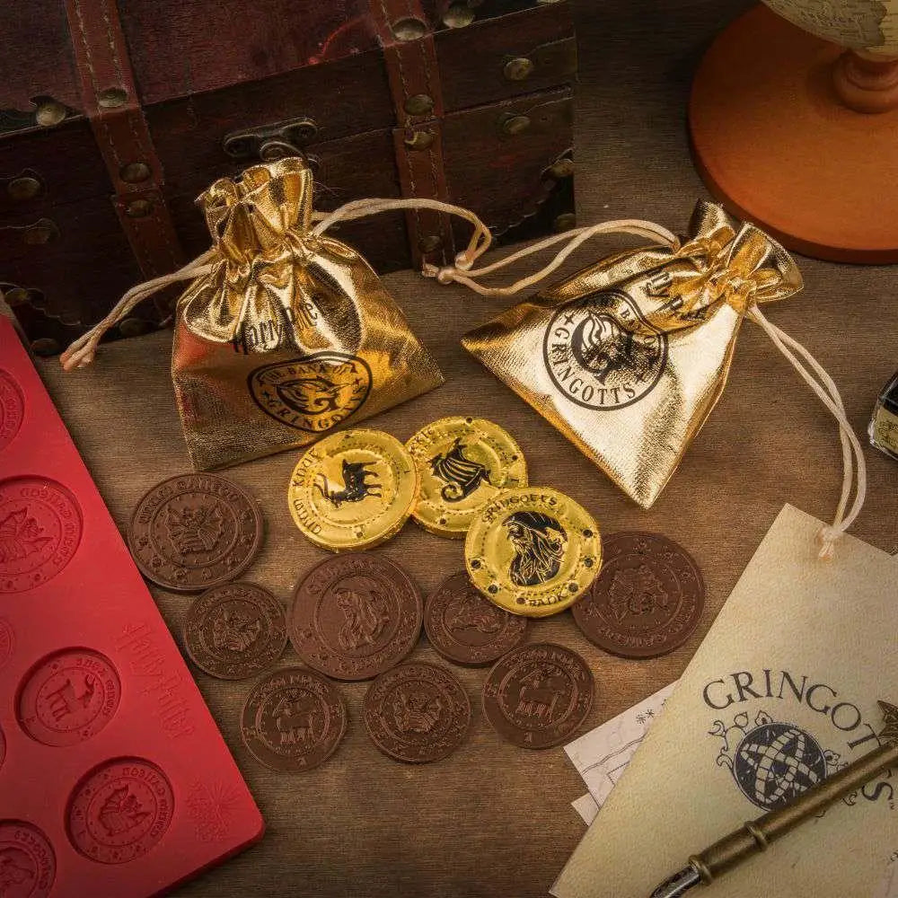 Guld- och silverchokladmyntformar med Hogwarts-emblem i dragsträngspåsar
