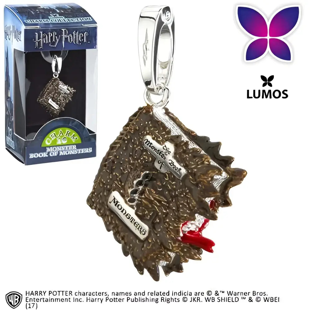 Silverfärgad metallcharm i form av Monsterboken från Harry Potter med ingraverad text och röd rosett