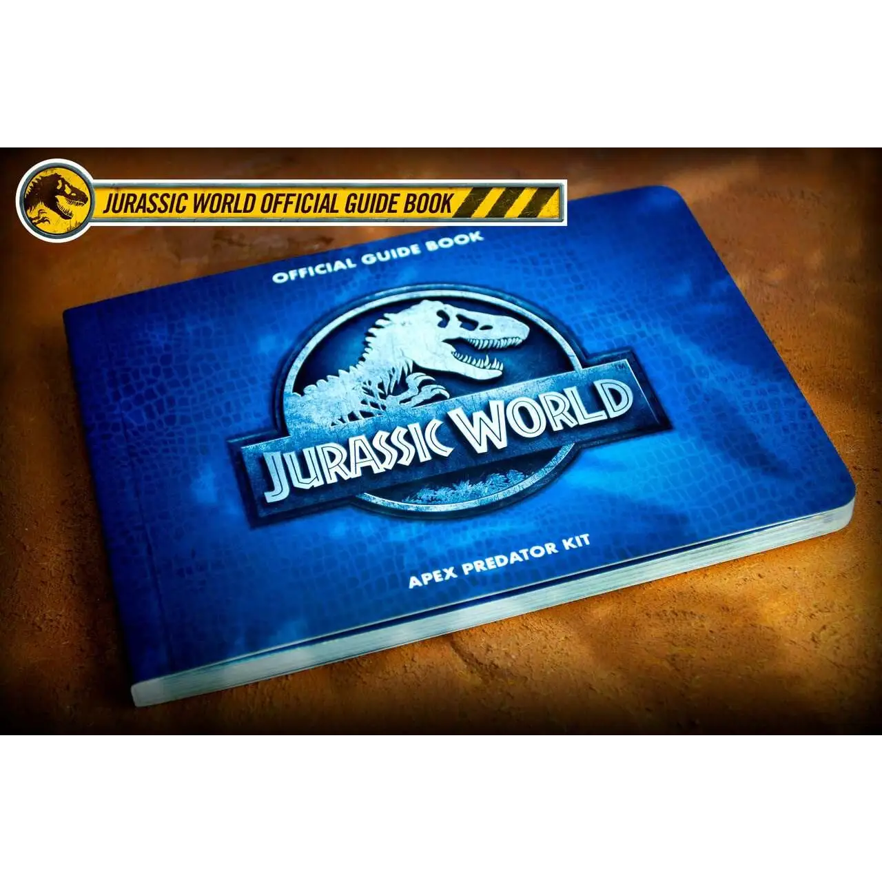 Blå hårdinbunden Jurassic World-guidebok med vit T i Apex Predator Kit