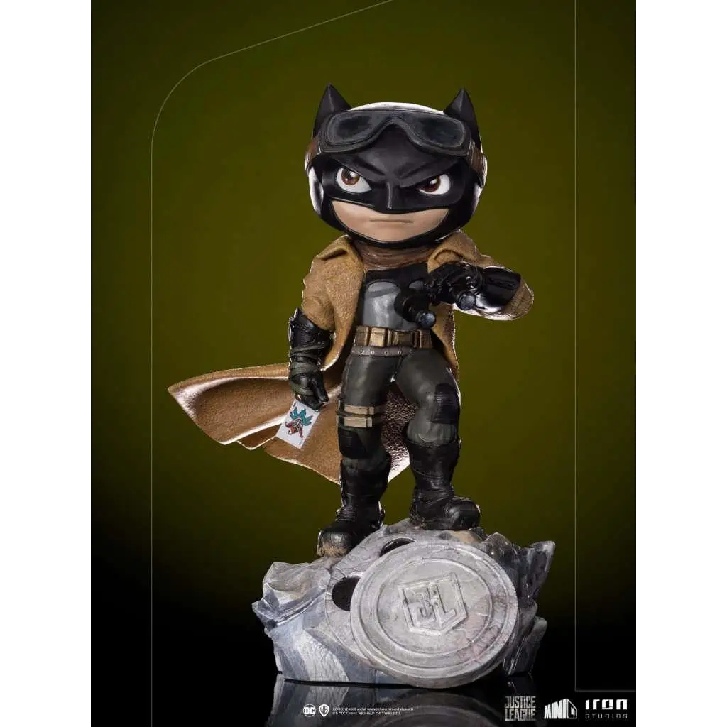 Chibi Justice League Knightmare Batman-statyett i svart och brun dräkt med glasögon på sprucken silveremblembas
