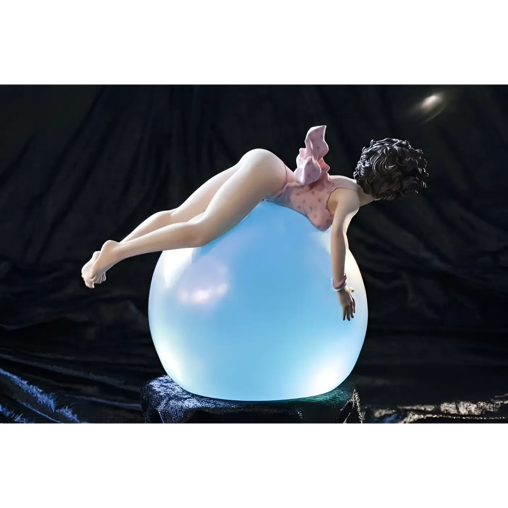 Glossig rosa prickig badklädd figurin med mörkt lockigt hår vilar på genomskinlig blå orb i Little Ego Bubble Dream Statue från Limitless Artistry