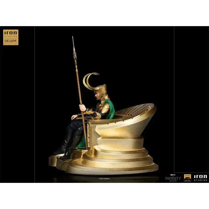 Guld Loki-statyn från Iron Studios, sittande på tron med grön mantel och spjut