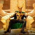Guld och svart Loki-staty från Iron Studios, sittande på utsmyckad tron med grön mantel