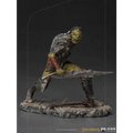 Grönskinnad orkkrigare i detaljerad metallrustning med rödinsvepta lemmar, svärd på stenbas från Lord of the Rings Orc Swordsman 1/10-statyett
