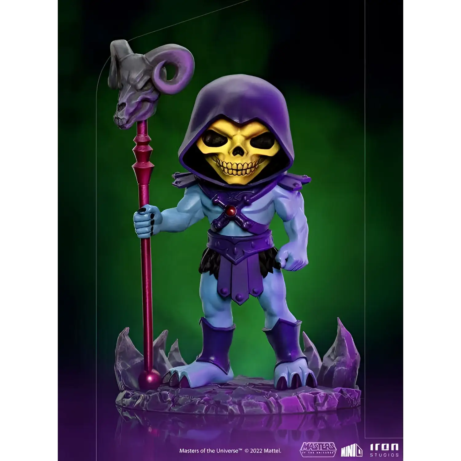 Lila huva Skeletor-figur med gul skalle, håller stav med ramlhuvud
