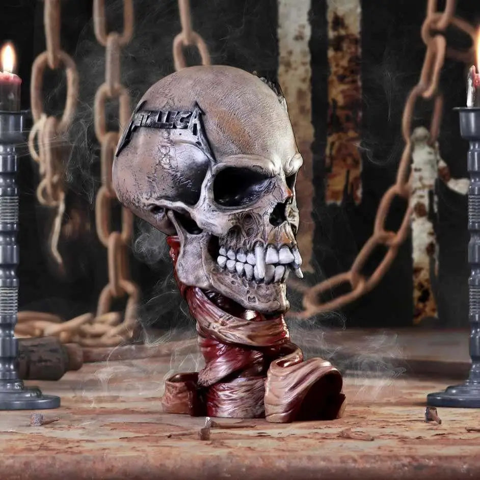 Metallica Pushead-skalle-statue med väderbiten metallfinish och röd tygdrapering