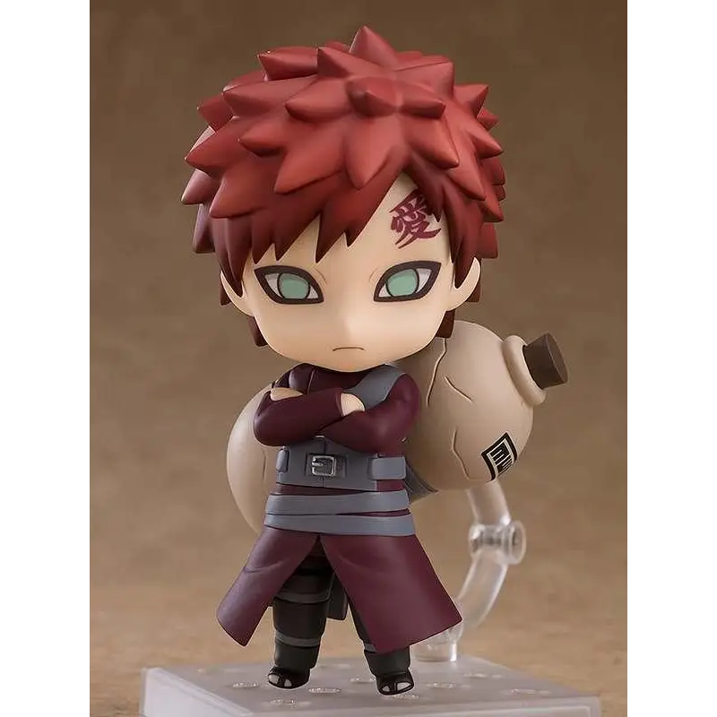 Röd-hårig chibi-figur av Gaara från Naruto med gröna ögon och röd kanji på pannan, i vinröd mantel, mörka byxor och beige ryggsäck