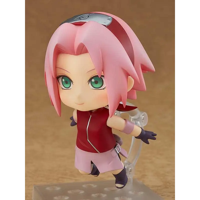 Rosa hårig Sakura Haruno Nendoroid-figur i röd-rosa outfit med gröna ögon och pannband