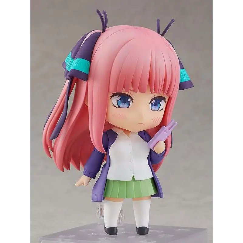 Nendoroid Nino Nakano: rosa hår, blå ögon, lila jacka, vit skjorta, grön kjol, håller lila föremål