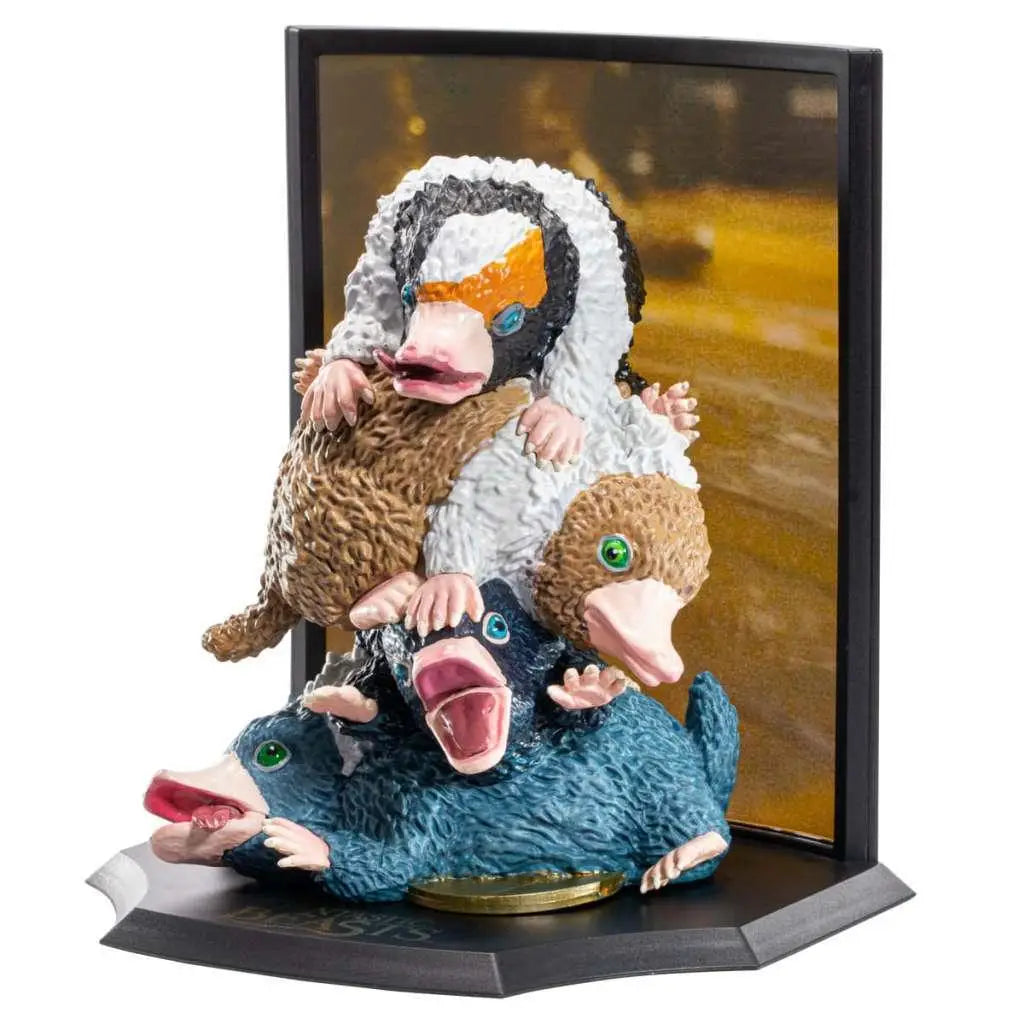 Detaljerad mångfärgad niffler-figurinsats med tre stapplade ungar på svart bas, Noble Collection