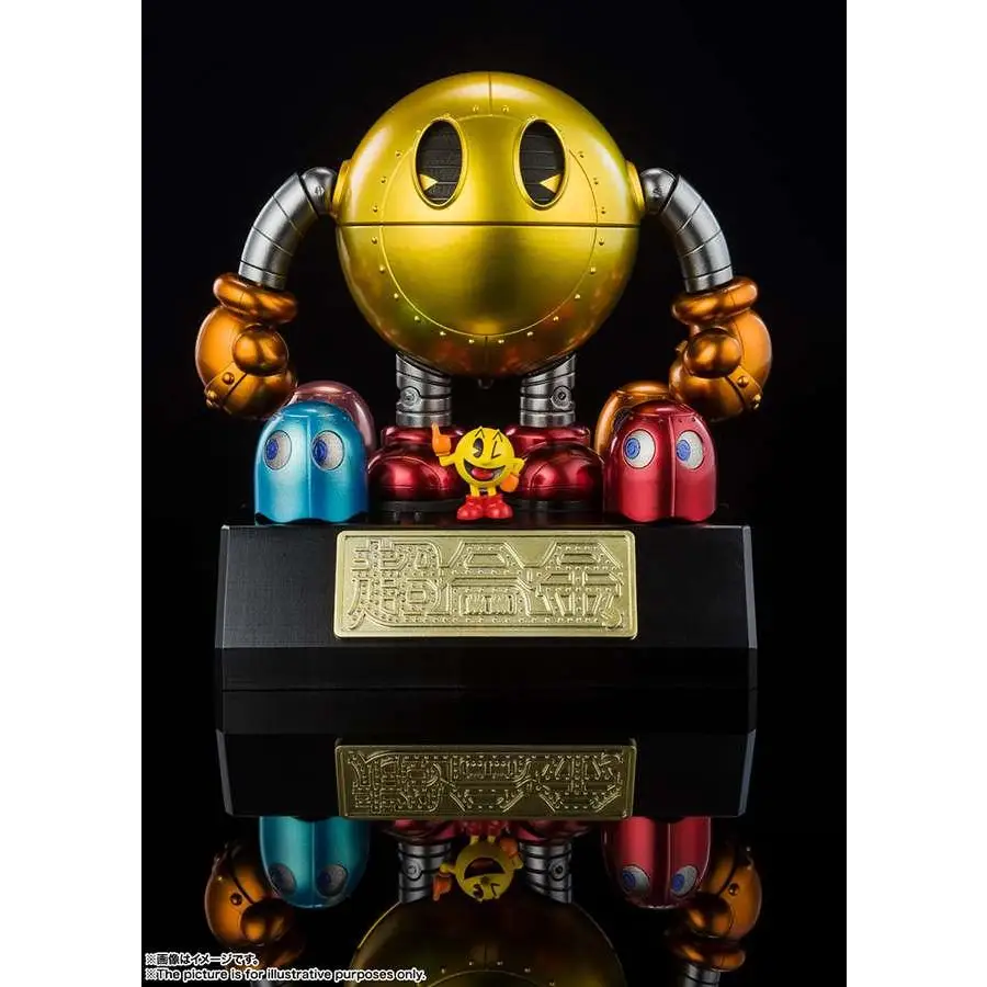 Guldmetallic Pac-Man Chogokin-robot med silverleder, orange nävar och svart bas med guldiga japanska tecken