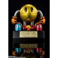 Guldmetallic Pac-Man Chogokin-robot med silverleder, orange nävar och svart bas med guldiga japanska tecken