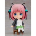 Rosa hårig animeflicka Nendoroid Quintessen Nino Swacchao! figurin med blå ögon i svart jacka, vit skjorta och grön kjol på trästol