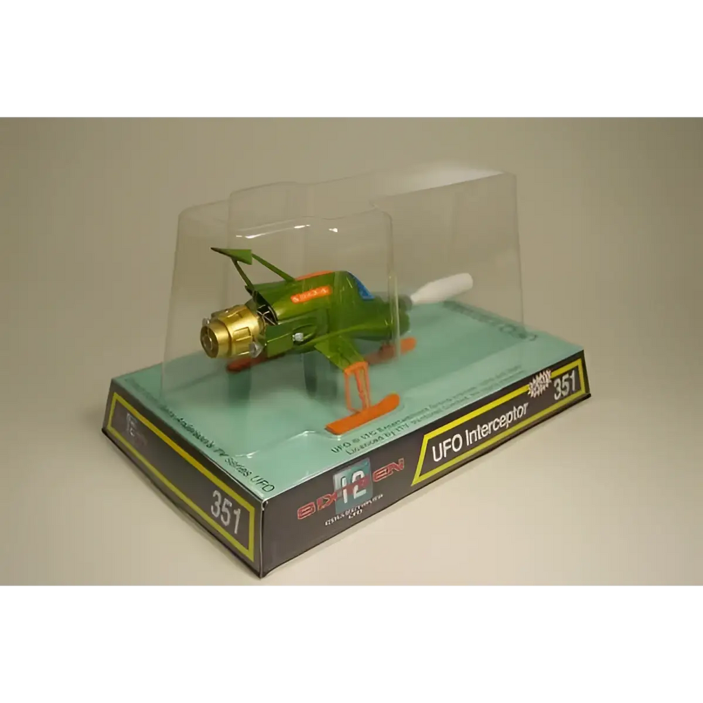 Retro UFO Interceptor leksaksflygplan i grön och guld med orange landningsställ i display