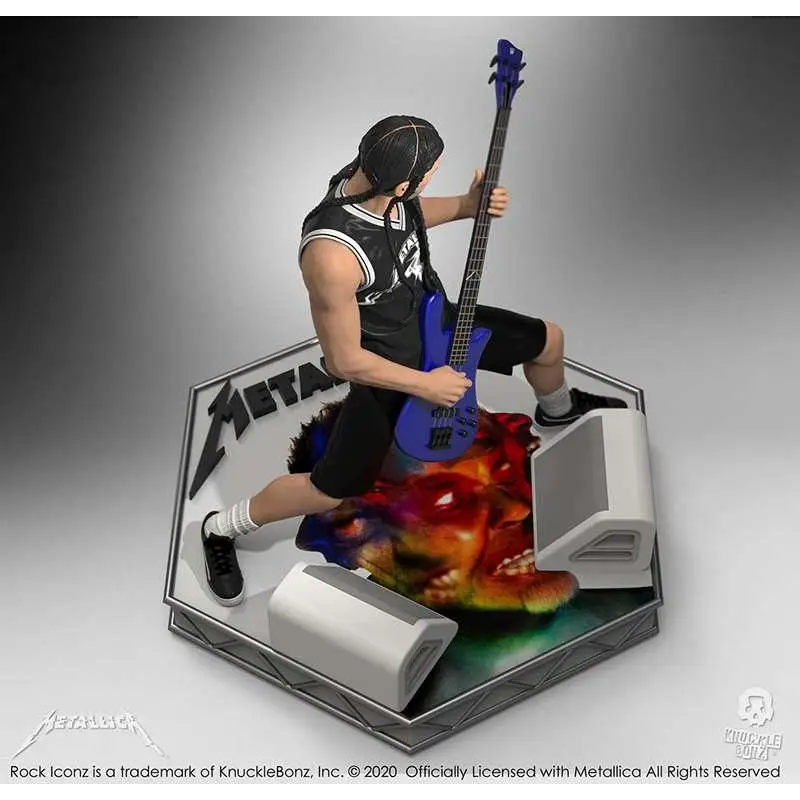 Blå basgitarr hålls av Metallica-figur i svartvitt, på oktagonal bas med bandnamn