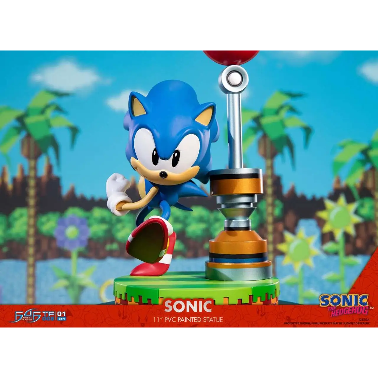 Blå Sonic the Hedgehog PVC-figur med röda och vita skor på grön bas bredvid metallisk speed booster