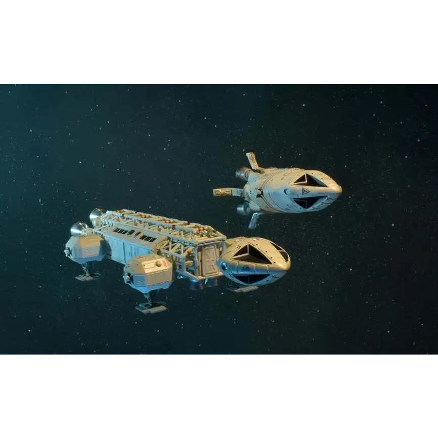Två vita och grå modellrymdskepp med detaljerade metallytor svävar i stjärnfyllt rymdscen från Space 1999 Dragons Domain Die-Cast Set