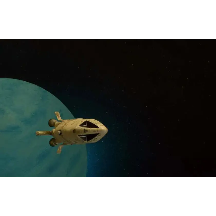 Beige rymdfarkost med spetsig nos och tre motorer glider förbi blå planet i Space 1999 Dragons Domain Die-Cast Set
