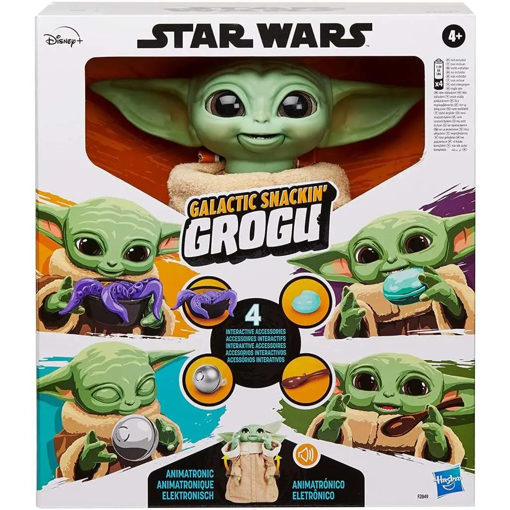 Grön animatronisk Grogu-leksak med stora svarta ögon och leende ansikte i tan robe