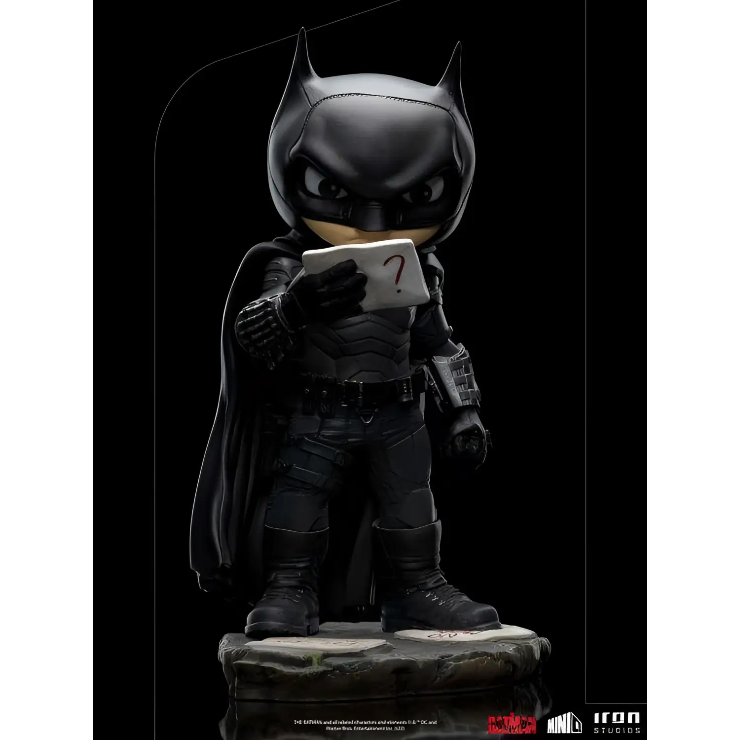 Svart Batman-figur i chibi-stil med taktisk dräkt, mantel och frågetecken-kort