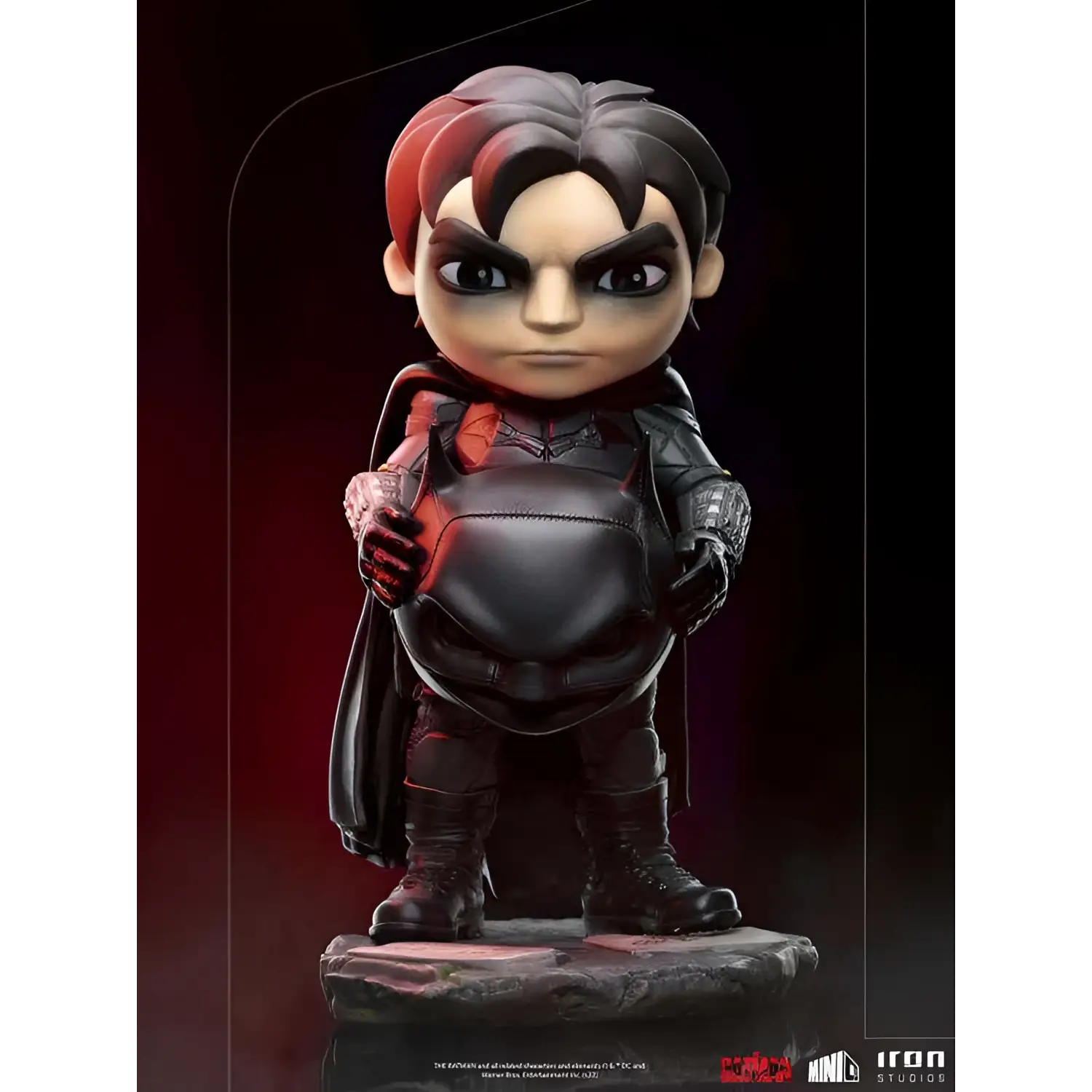 Chibi Batman i svart och röd rustning med mantel på stenbas