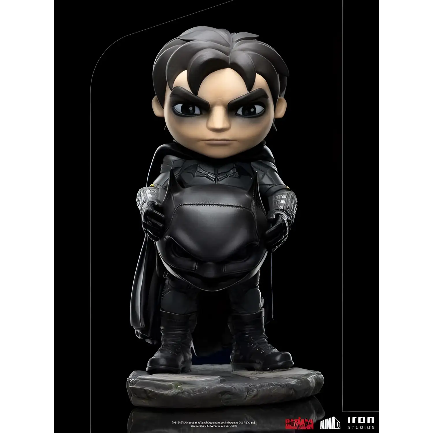 Svart Batman-figur med detaljerad rustning och mantel på stenbas
