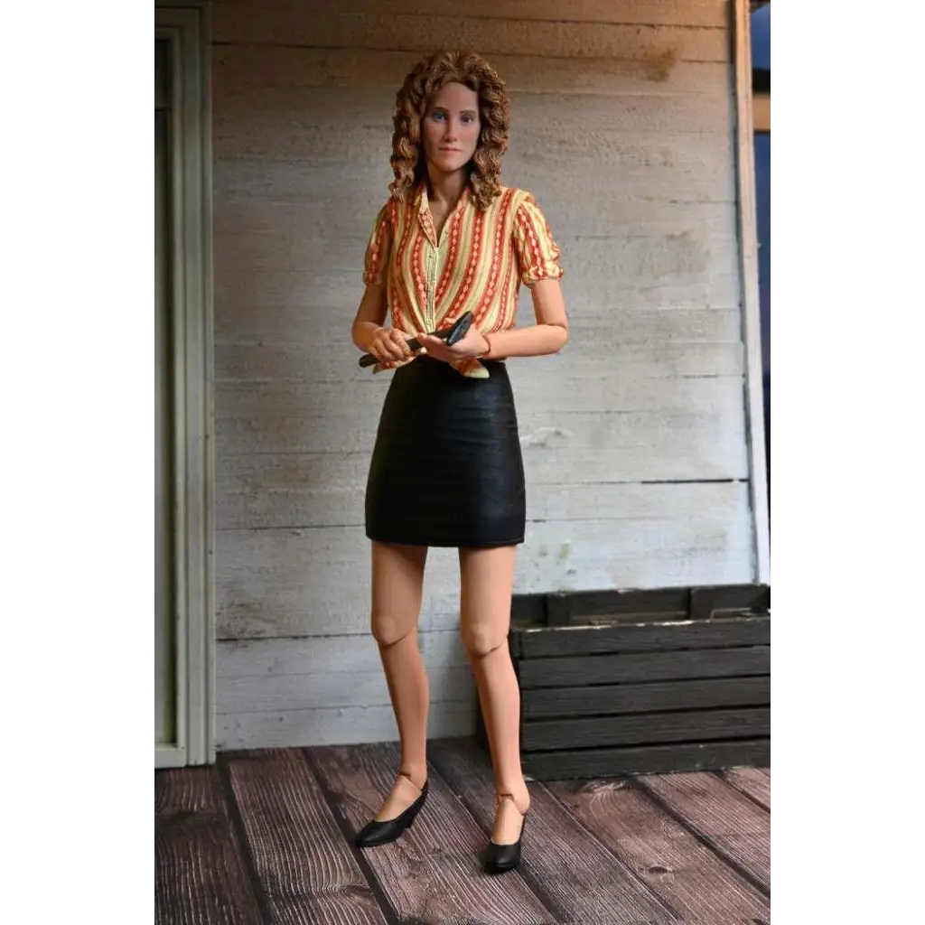 Detaljerad actionfigur av April från TMNT 1990-film med lockigt brunt hår i orange-gul randig tröja och svart kjol