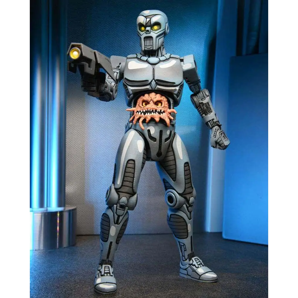 Silver and gray TMNT Utrom robot exoskeleton action figure with glowing yellow eyes, holding a gun, and orange alien protruding from chest