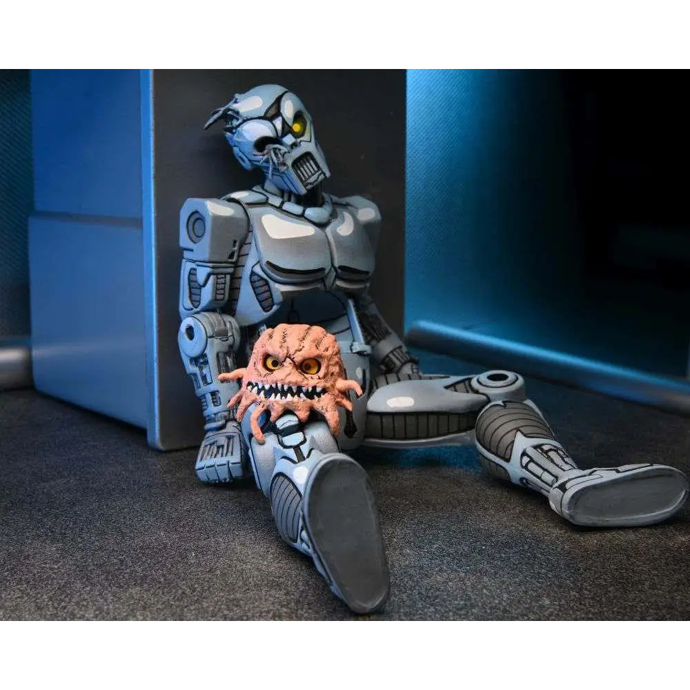 Silvrig robotexoskelett med gula ögon håller liten orange varelse, TMNT Utrom AF