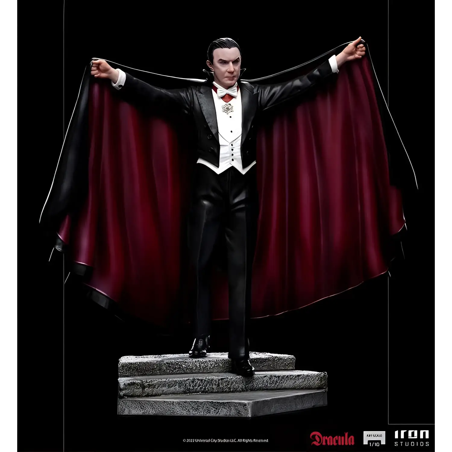 Svart och vinröd mantelklädd Dracula-staty i smoking med silverbrosch på stensteg
