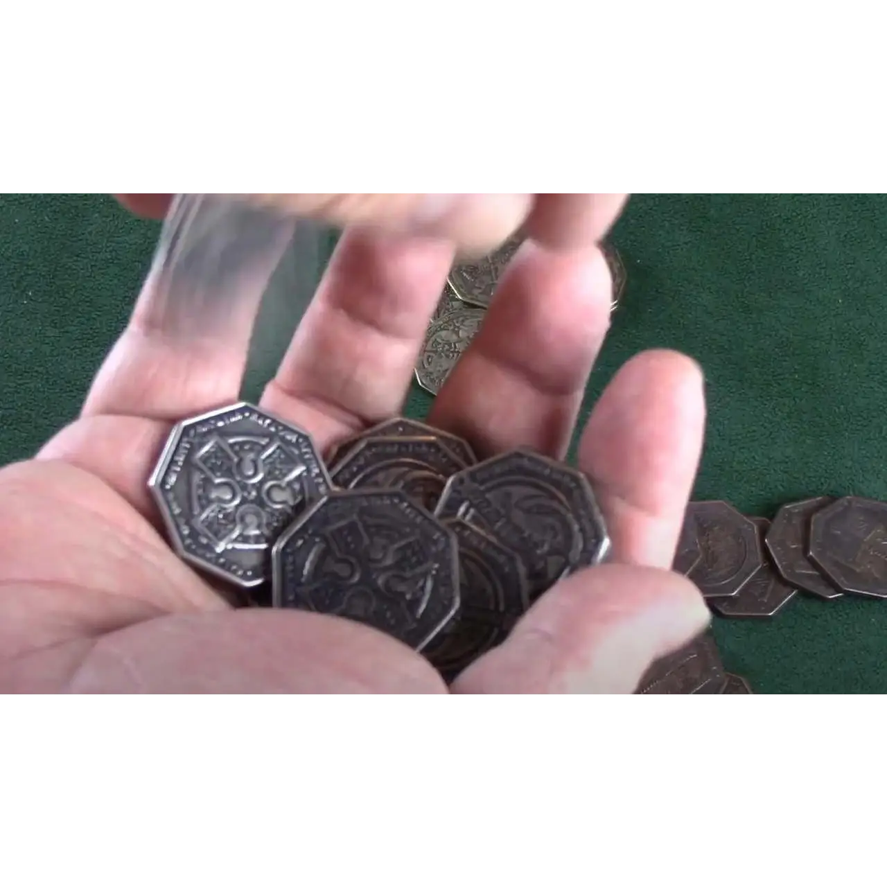 Hand holding Vampir Metallmynt Set (24) with dark octagonal coins