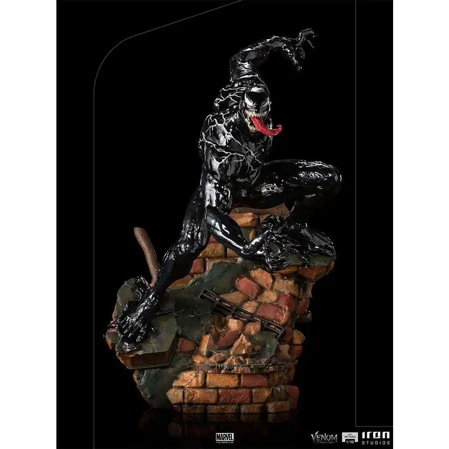 Svart Venom-statue med röd tunga och vita ögon på tegelväggsbas